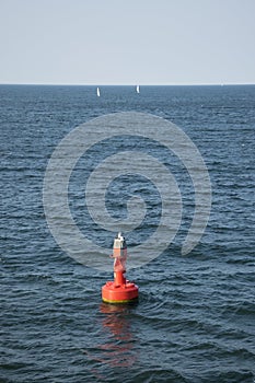 Red buoy floating atÂ open sea